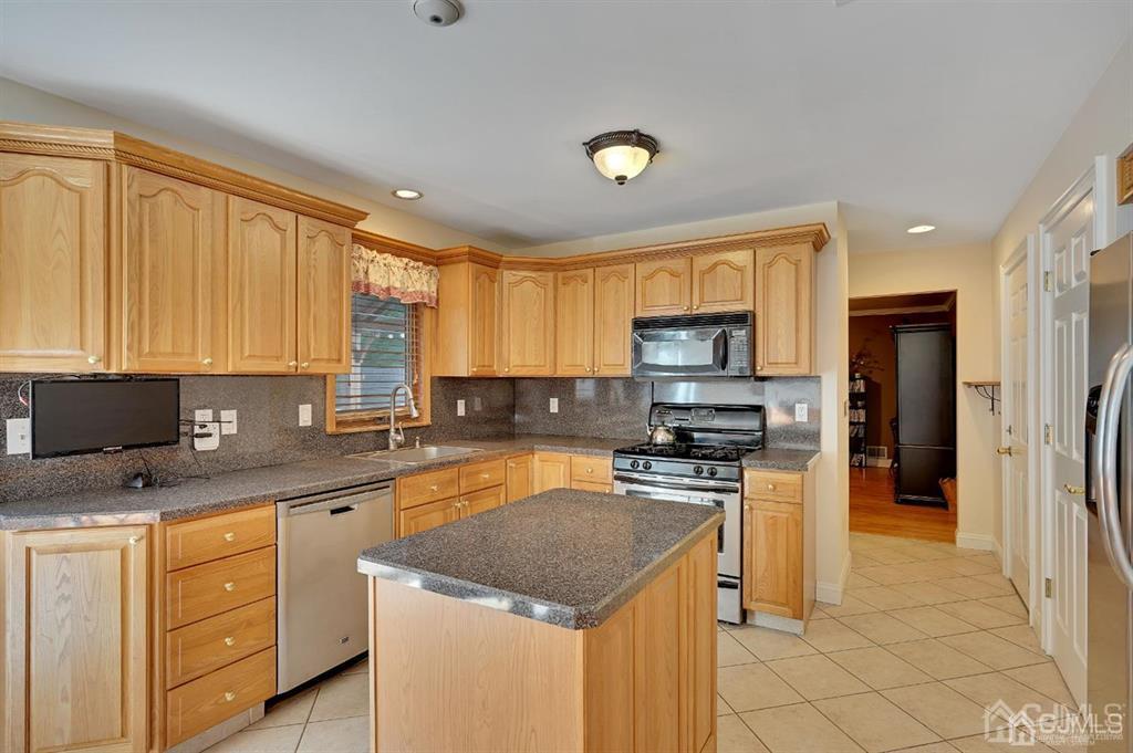 83 Amboy Road Old Bridge, NJ 07747 - Photo 10 of 40 a kitchen with stainless steel appliances granite countertop a stove a sink dishwasher a refrigerator and cabinets with wooden floor