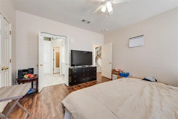 a bedroom with a bed and a flat tv screen on wall