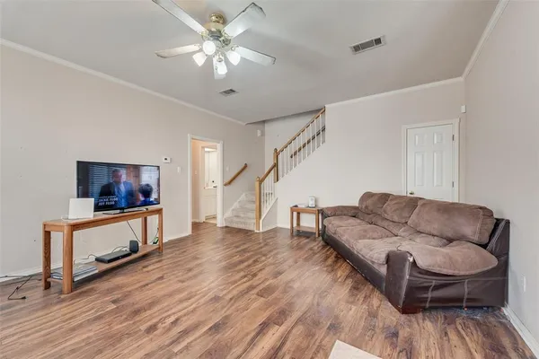 a living room with furniture and a wooden floor