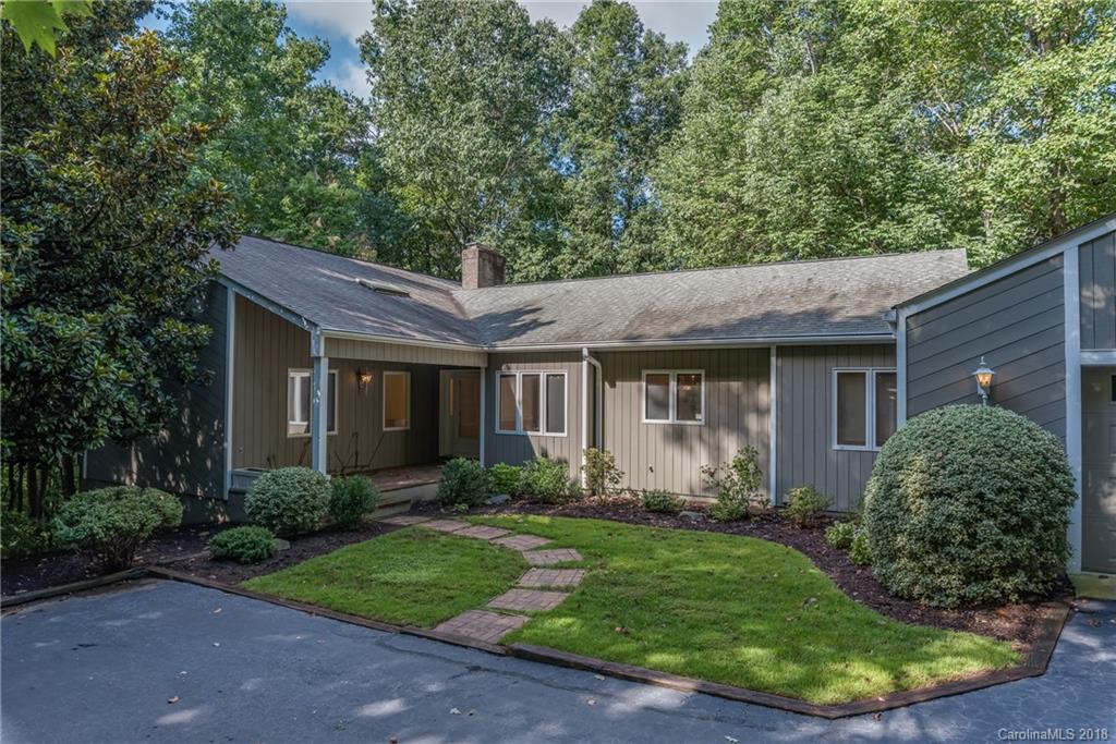 688 Laurel Ridge Road Columbus, NC 28722 - Photo 1 of 30 a view of a house with brick walls plants and large tree