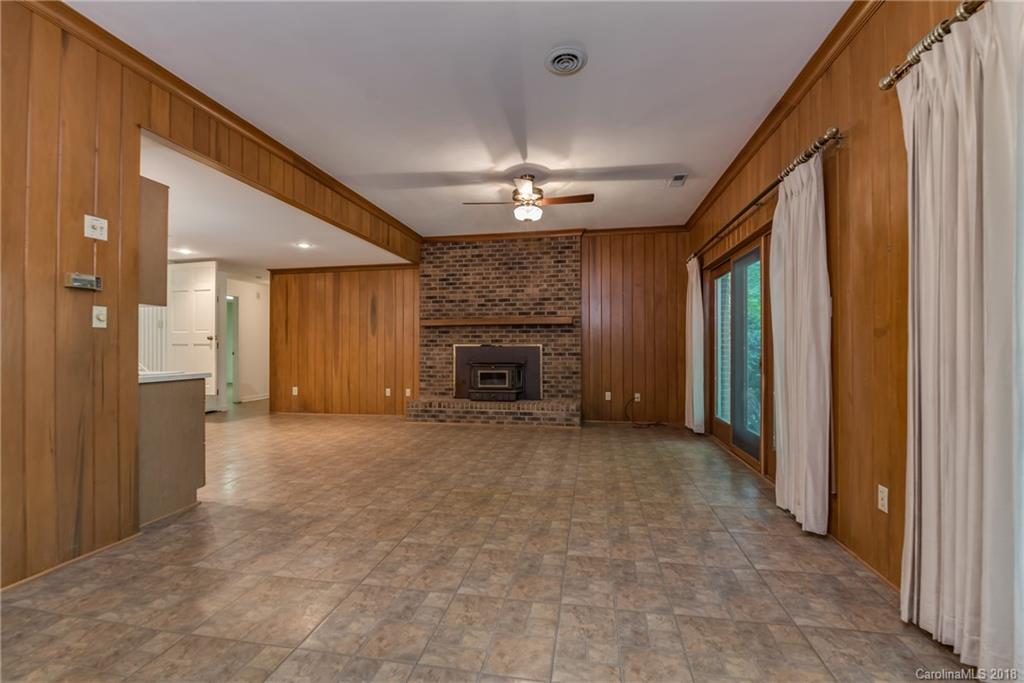 688 Laurel Ridge Road Columbus, NC 28722 - Photo 22 of 30 a view of an empty room with a fireplace and a window