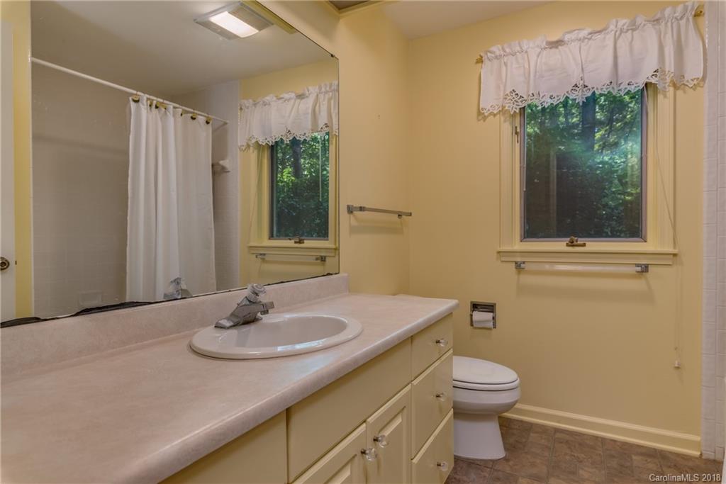 688 Laurel Ridge Road Columbus, NC 28722 - Photo 25 of 30 a bathroom with a granite countertop sink toilet and shower