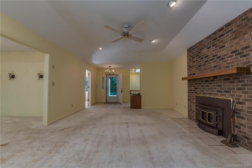 688 Laurel Ridge Road Columbus, NC 28722 - Photo 5 of 30 an empty room with fireplace and fan