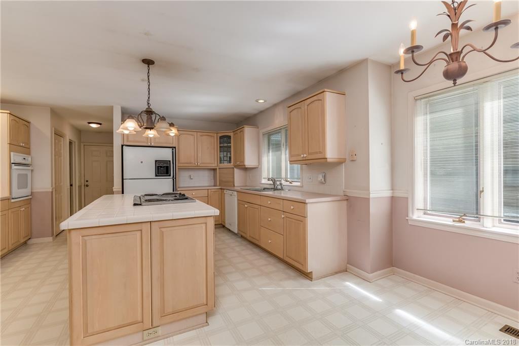 688 Laurel Ridge Road Columbus, NC 28722 - Photo 7 of 30 a kitchen that has a lot of white cabinets and stainless steel appliances