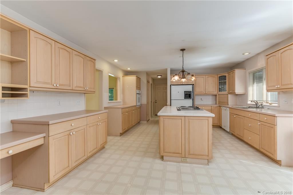 688 Laurel Ridge Road Columbus, NC 28722 - Photo 8 of 30 a kitchen with kitchen island granite countertop a stove a sink a center island and cabinets