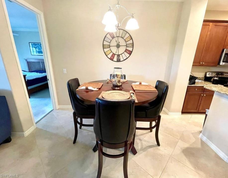 9050 Capistrano Street North, Unit 4102 Naples, FL 34113 - Photo 7 of 31 a dining room with furniture and wooden floor