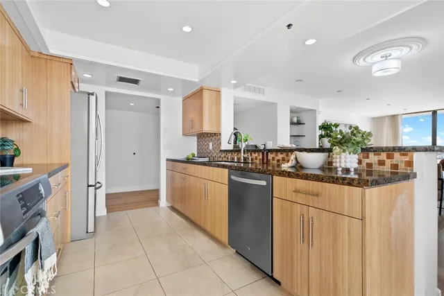 a kitchen with granite countertop a stove top oven and cabinets