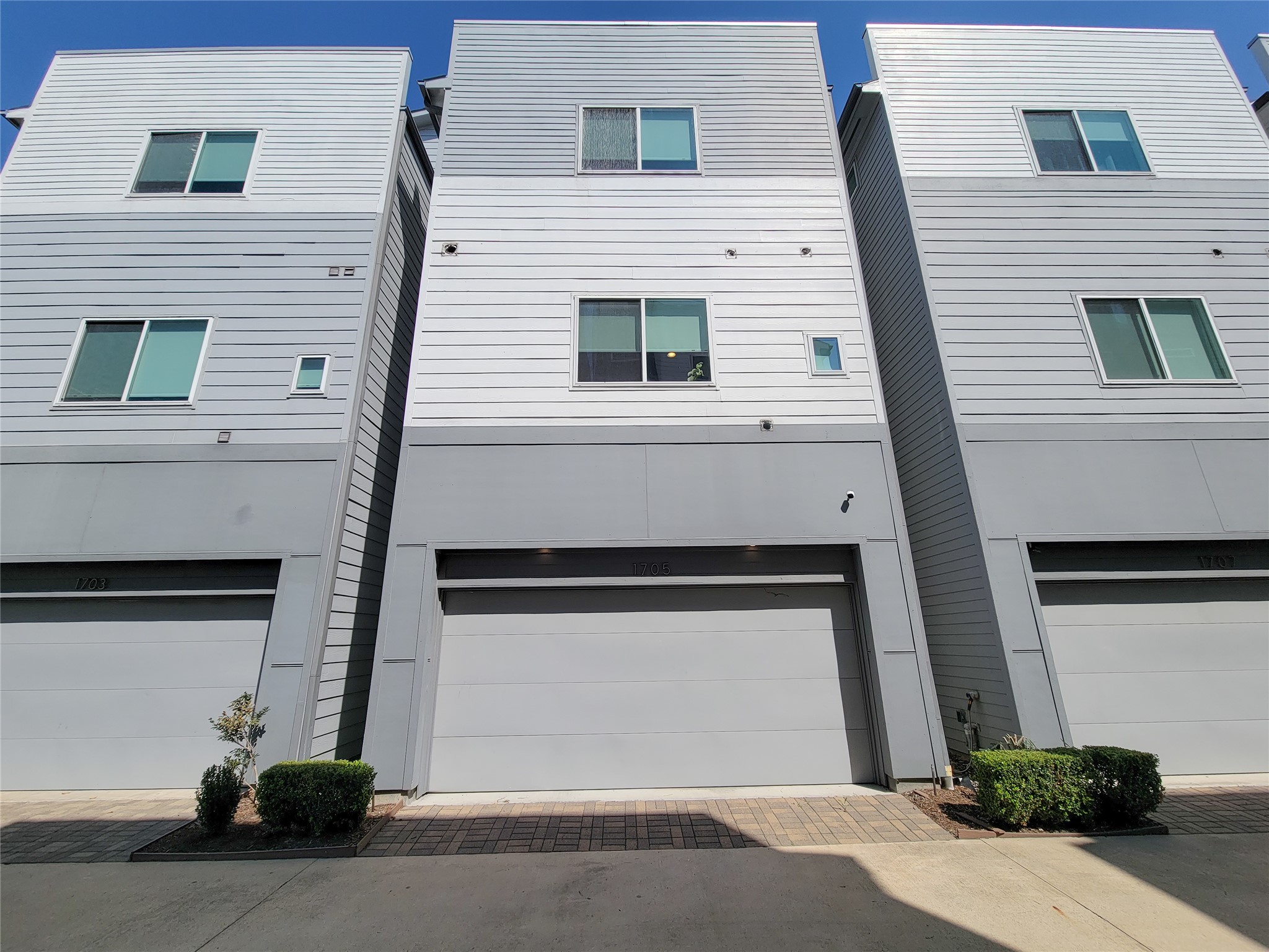 1705 Eado Point Lane Houston, TX 77003 - Photo 46 of 50 Modern 4-story townhouse with a sleek, minimalist design. Features large windows for natural light and a spacious garage. Simple landscaping enhances curb appeal.