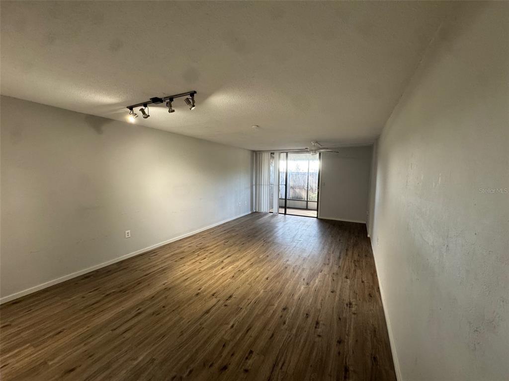 717 Southwest 75th Street, Unit 103 Gainesville, FL 32607 - Photo 2 of 13 a view of an empty room with wooden floor