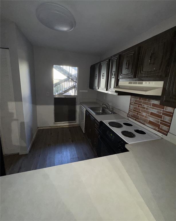 717 Southwest 75th Street, Unit 103 Gainesville, FL 32607 - Photo 4 of 13 a kitchen with granite countertop a stove wooden floor and a window