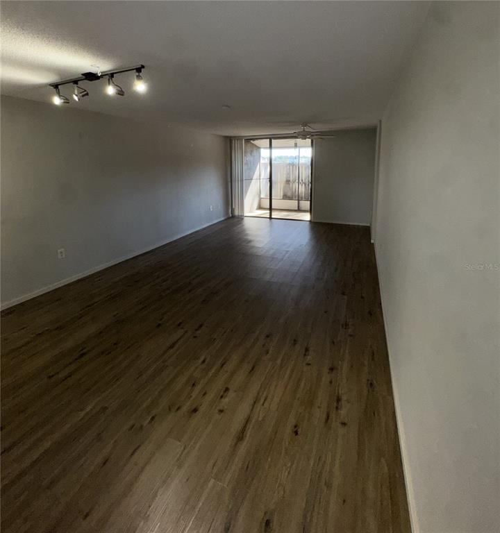 717 Southwest 75th Street, Unit 103 Gainesville, FL 32607 - Photo 5 of 13 a view of an empty room with wooden floor