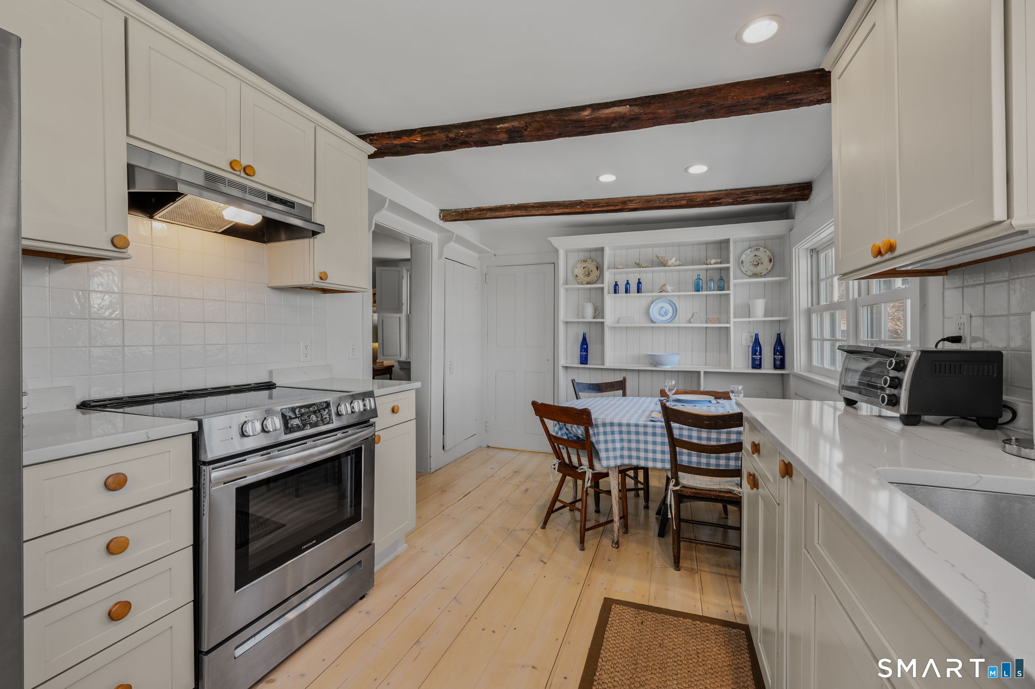 20 Diving Street Stonington, CT 06378 - Photo 13 of 33 a kitchen with a stove a table and chairs in it
