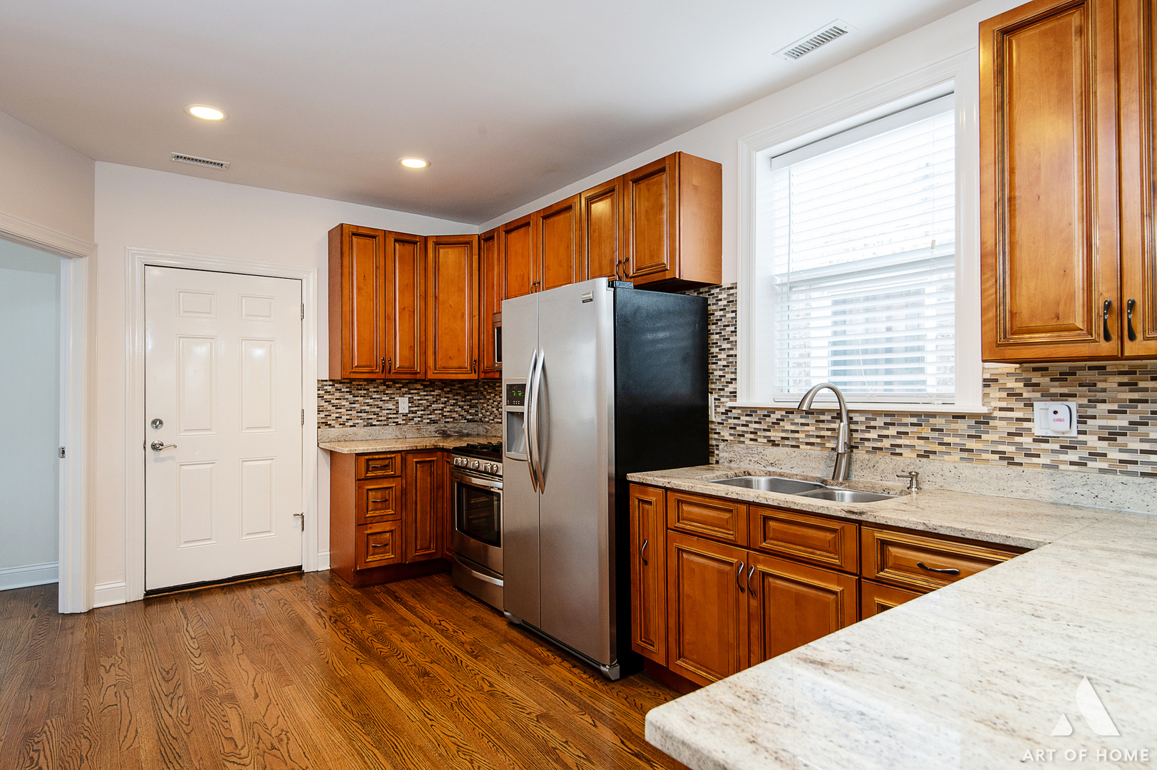 4820 West George Street, Unit 2 Chicago, IL 60641 - Photo 15 of 24 a kitchen with stainless steel appliances granite countertop a refrigerator a sink dishwasher and wooden cabinets with wooden floor