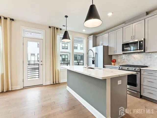 a kitchen with kitchen island granite countertop a stove cabinets and refrigerator
