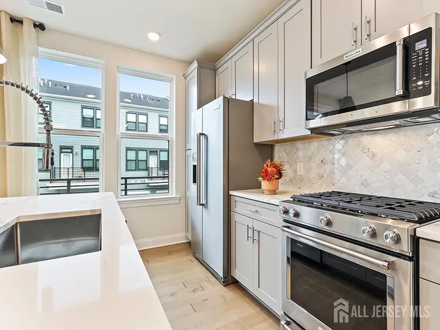 a kitchen with stainless steel appliances granite countertop a stove microwave and refrigerator