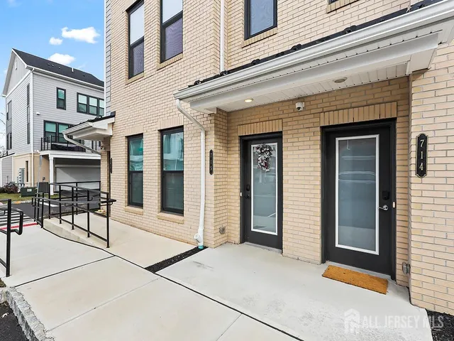 a front view of a building with glass door and furniture