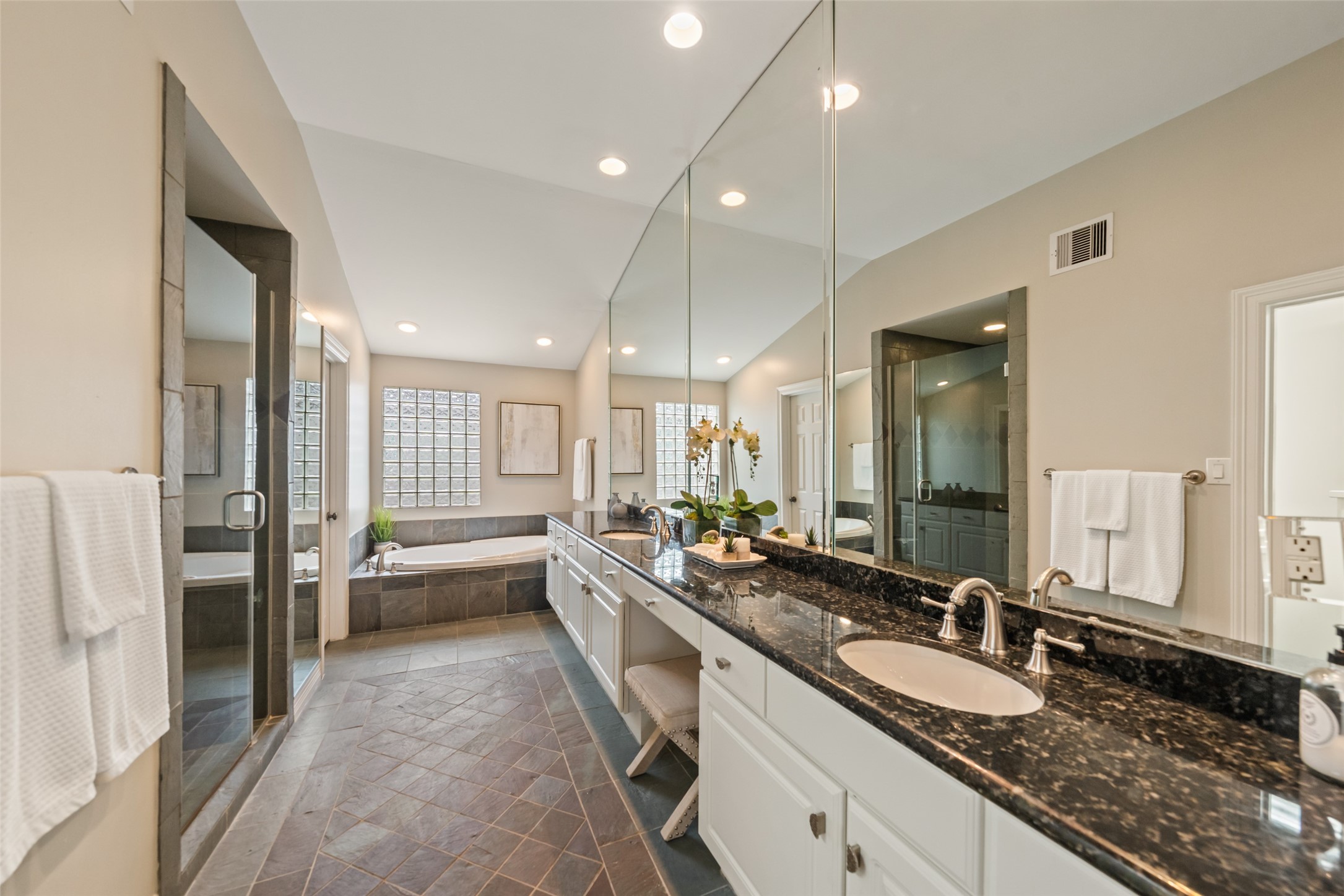2708 Wroxton Road West University Place, TX 77005 - Photo 7 of 22 Indulge in luxury in this spa-like primary bath featuring a soaking tub with sprayer, separate shower, expansive granite counter with double sinks, and ample storage. Plus, enjoy the convenience of a linen closet with ShelfGenie pull-out drawers.