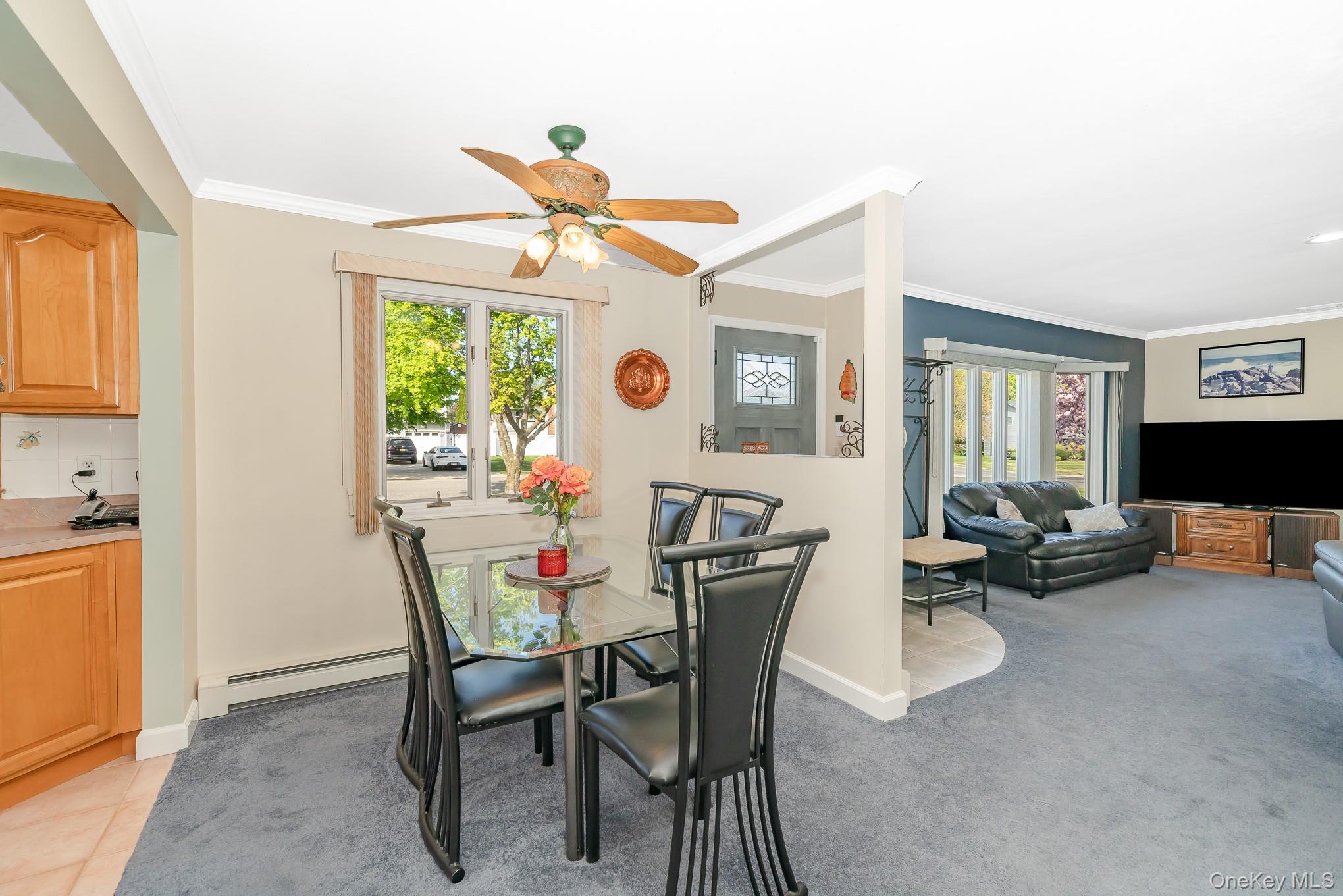 18 Byron Road Commack, NY 11725 - Photo 11 of 32 Dining area featuring a ceiling fan with integrated lighting, a window, and broadloom carpeting