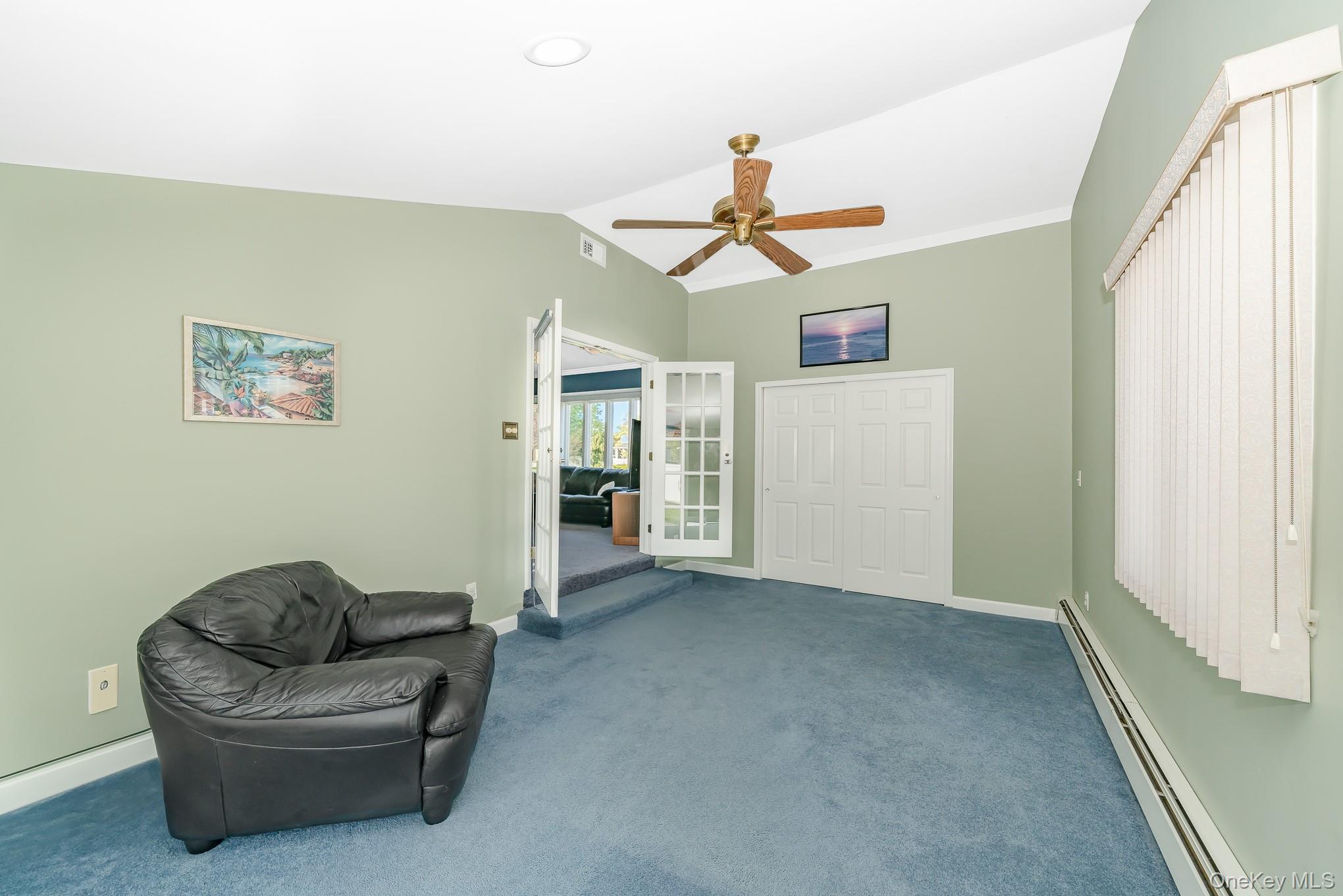 18 Byron Road Commack, NY 11725 - Photo 16 of 32 Vaulted ceiling room featuring blue carpet, a ceiling fan, and double French doors opening to formal living room