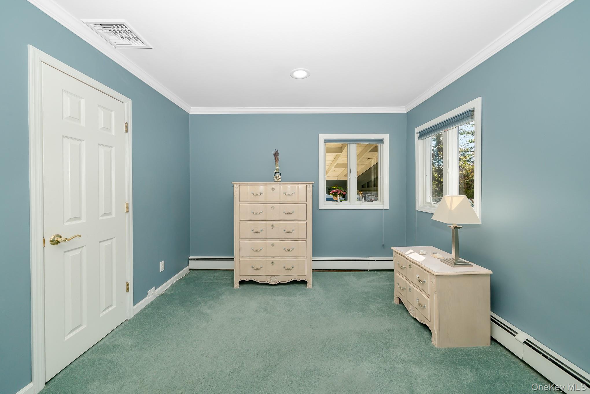18 Byron Road Commack, NY 11725 - Photo 19 of 32 Room featuring white crown molding, two windows with white trim, and light blue walls