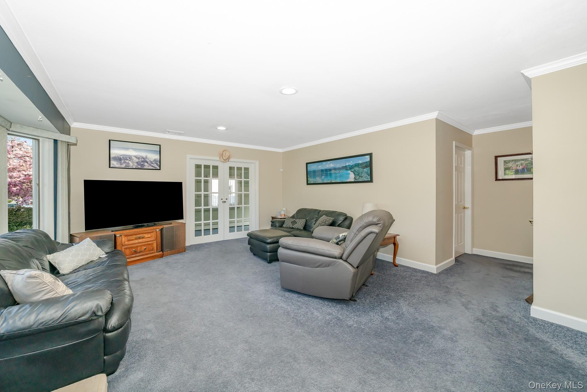 18 Byron Road Commack, NY 11725 - Photo 8 of 32 Spacious living area featuring carpeted flooring, (hardwood floors under carpet) light neutral wall tones, and white crown molding