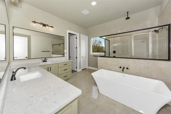 a bathroom with a tub sink and mirror