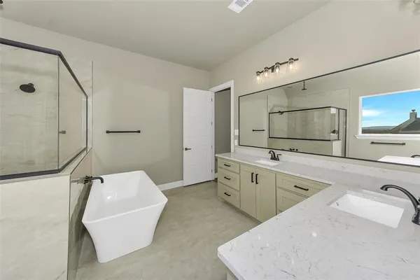 a spacious bathroom with a tub sink and mirror