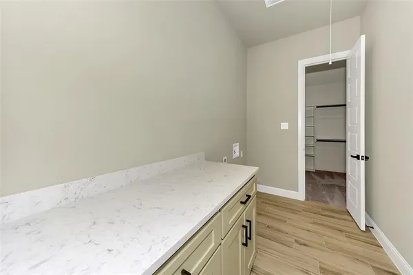 a room with a wooden floor and cabinets