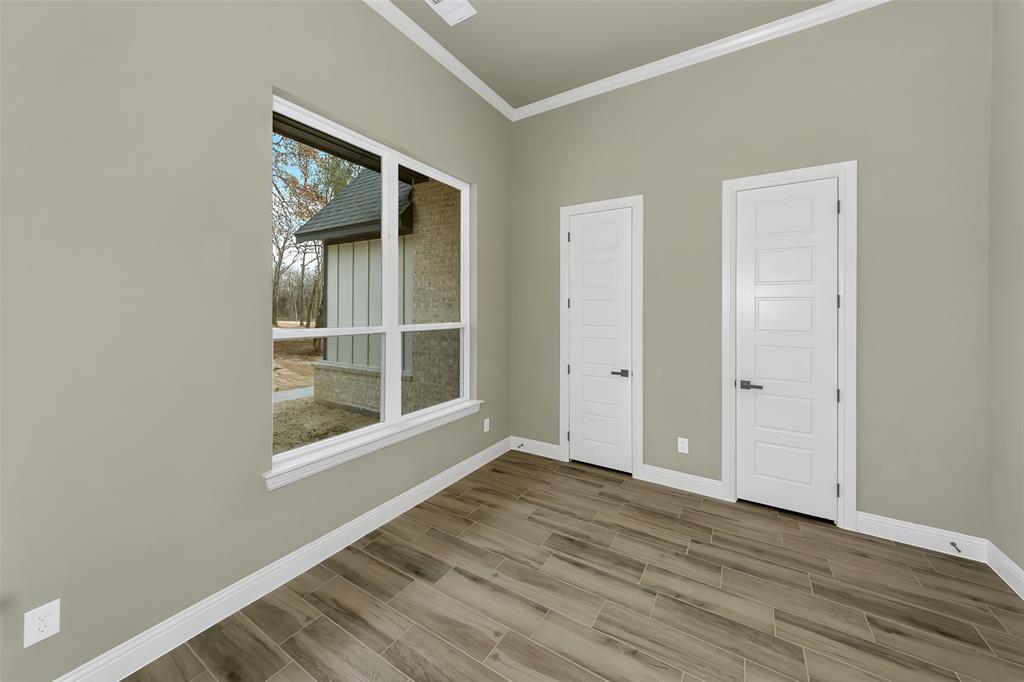 1057 Vh Ranch Poolville, TX 76487 - Photo 4 of 33 an empty room with wooden floor and windows