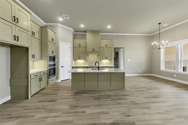 a large kitchen with kitchen island a sink stainless steel appliances and cabinets