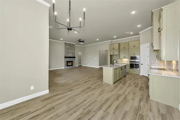 a open kitchen view with wooden floor and stainless steel appliances