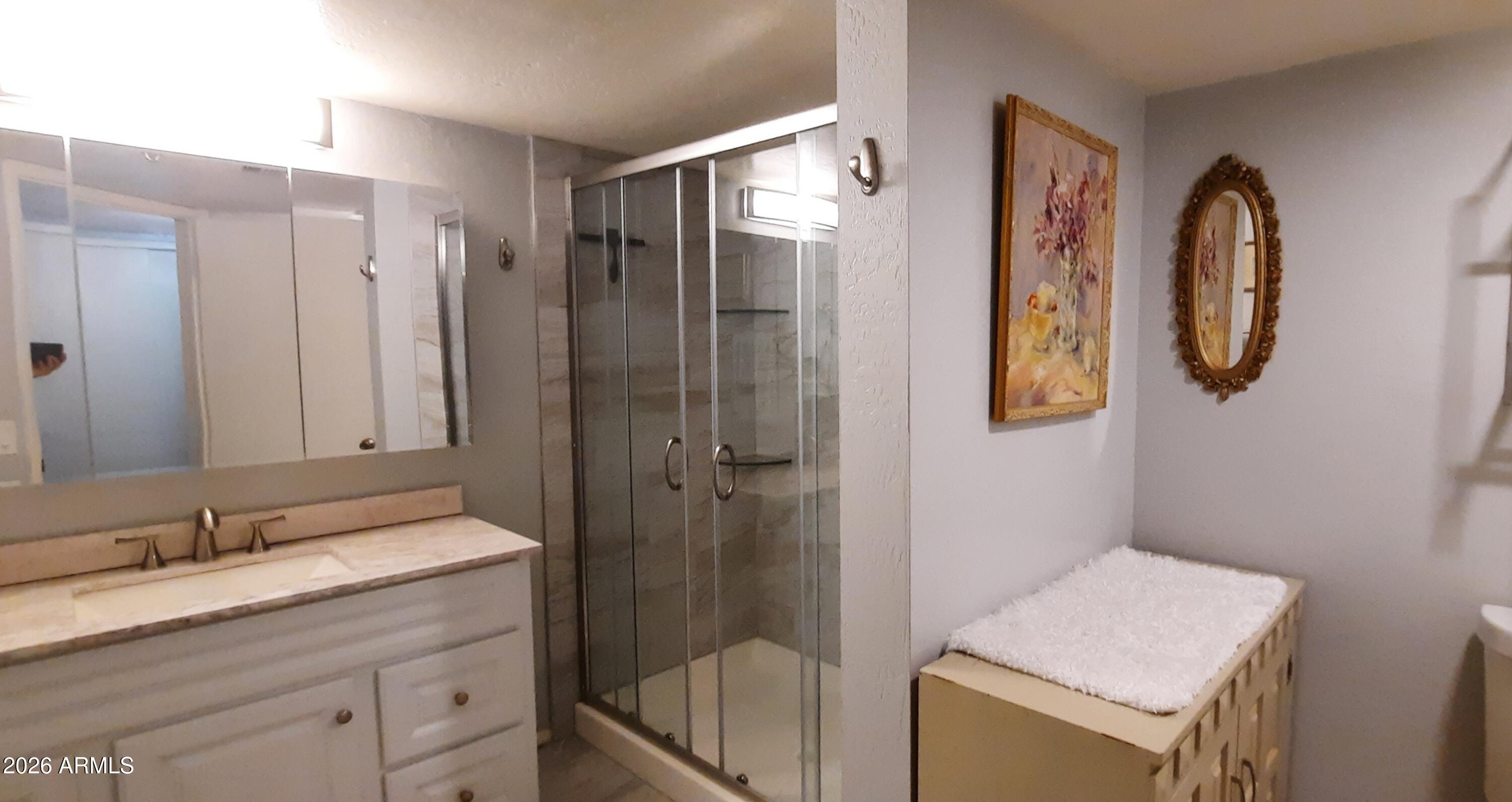 12221 West Bell Road, Unit 149 Surprise, AZ 85378 - Photo 16 of 28 a bathroom with a granite countertop sink and a mirror