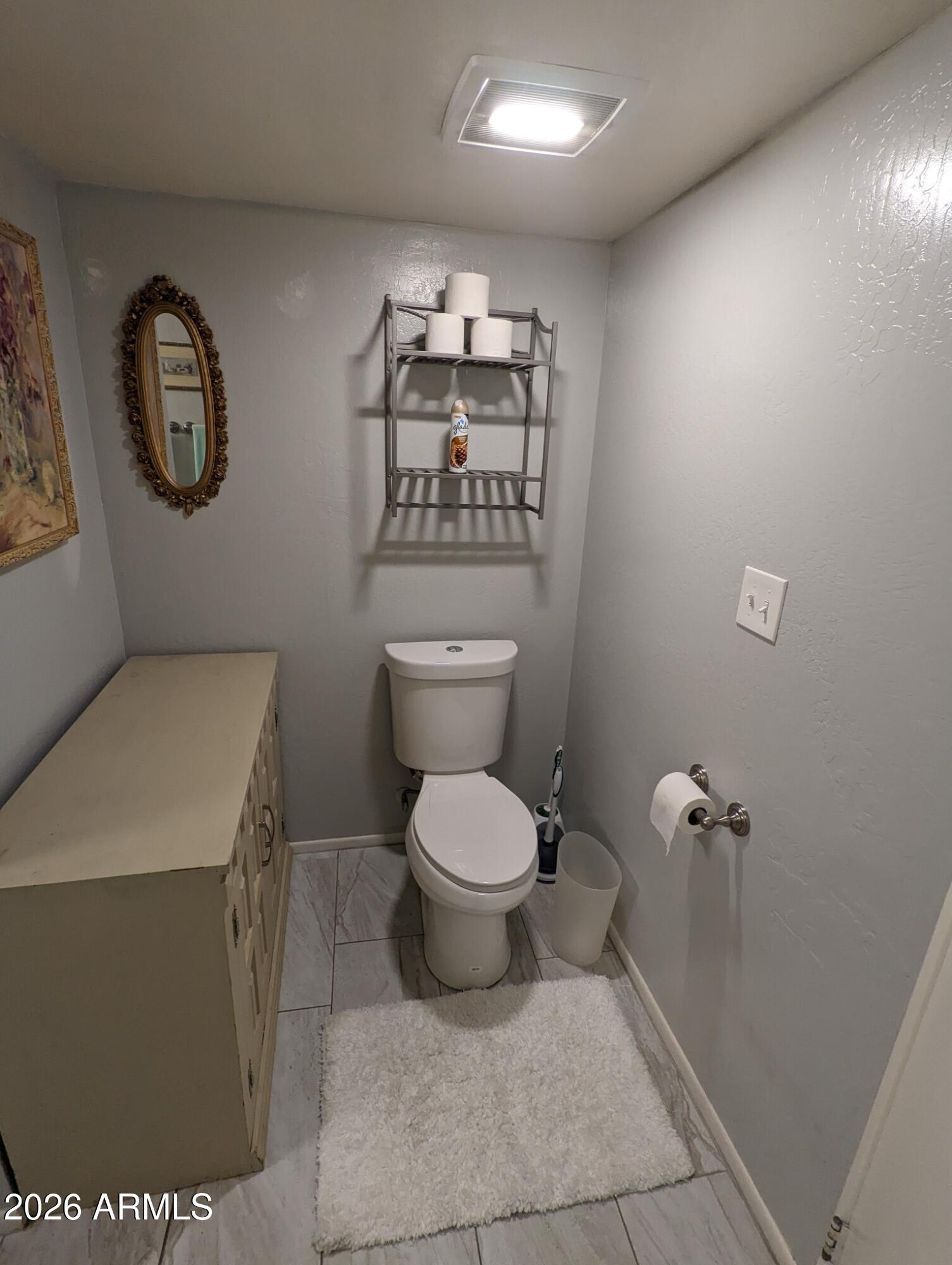 12221 West Bell Road, Unit 149 Surprise, AZ 85378 - Photo 19 of 28 a bathroom with a toilet a sink and a mirror