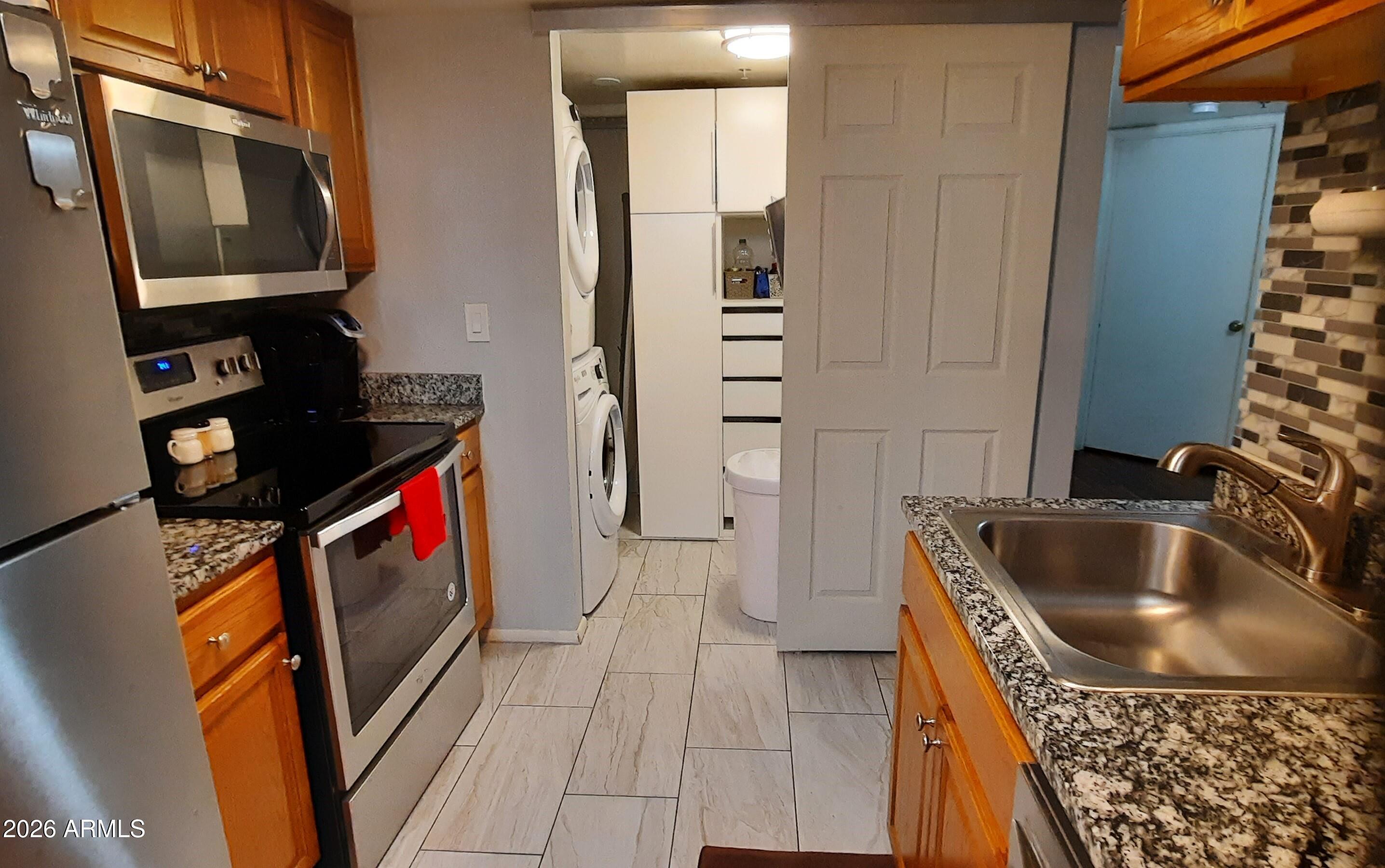12221 West Bell Road, Unit 149 Surprise, AZ 85378 - Photo 6 of 28 a kitchen with a sink a stove and a refrigerator