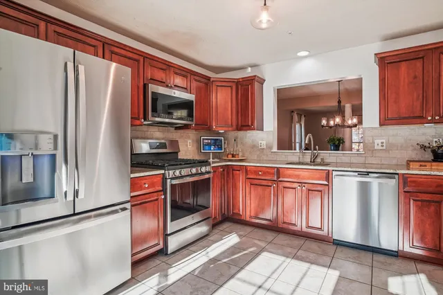 a kitchen with stainless steel appliances granite countertop a refrigerator stove top oven a sink and dishwasher