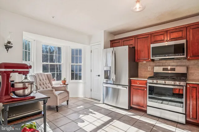 a kitchen with stainless steel appliances a stove a refrigerator and a microwave