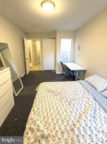 a bedroom with a bed a dresser and a book shelf