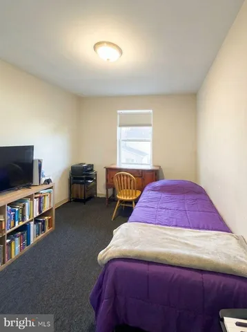 a spacious bedroom with a bed a dresser and a window
