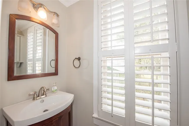 a bathroom with a sink a mirror and a window