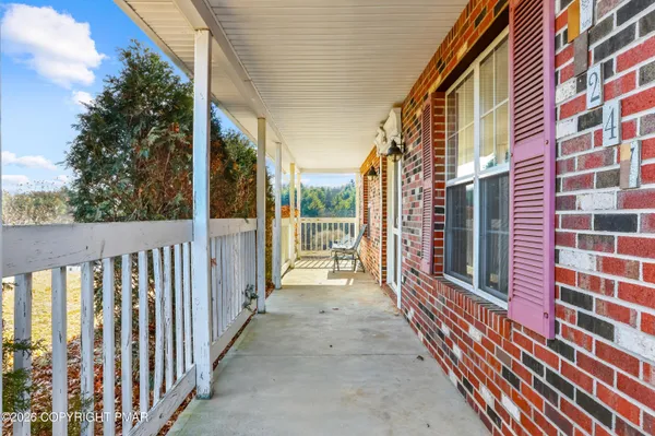 a kitchen with stainless steel appliances kitchen island granite countertop a refrigerator a sink a stove and white cabinets with wooden floor