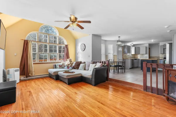 a living room with furniture a large window and wooden floor