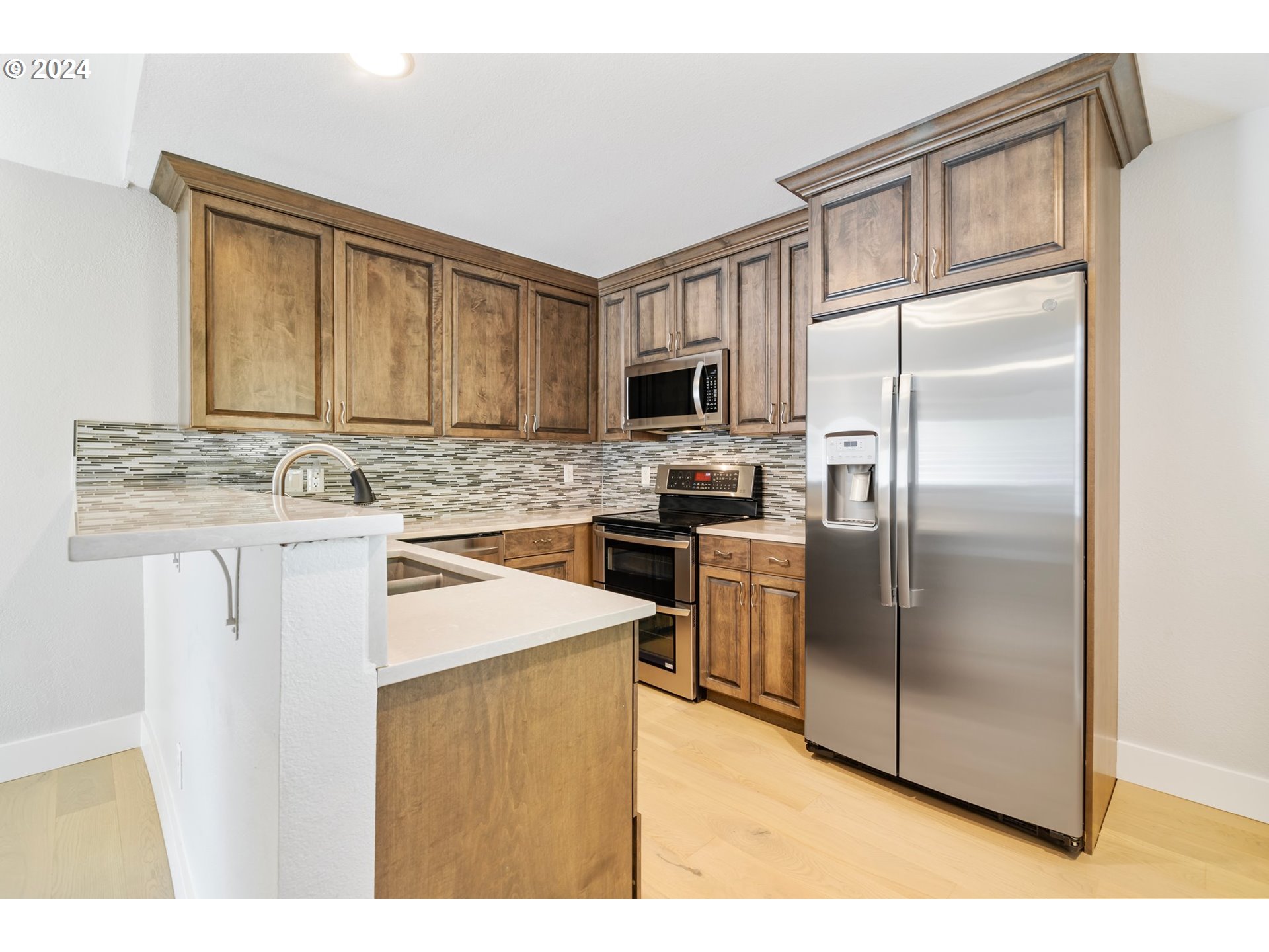 5225 Jean Road, Unit 501 Lake Oswego, OR 97035 - Photo 6 of 38 a kitchen with kitchen island a counter top space cabinets and stainless steel appliances