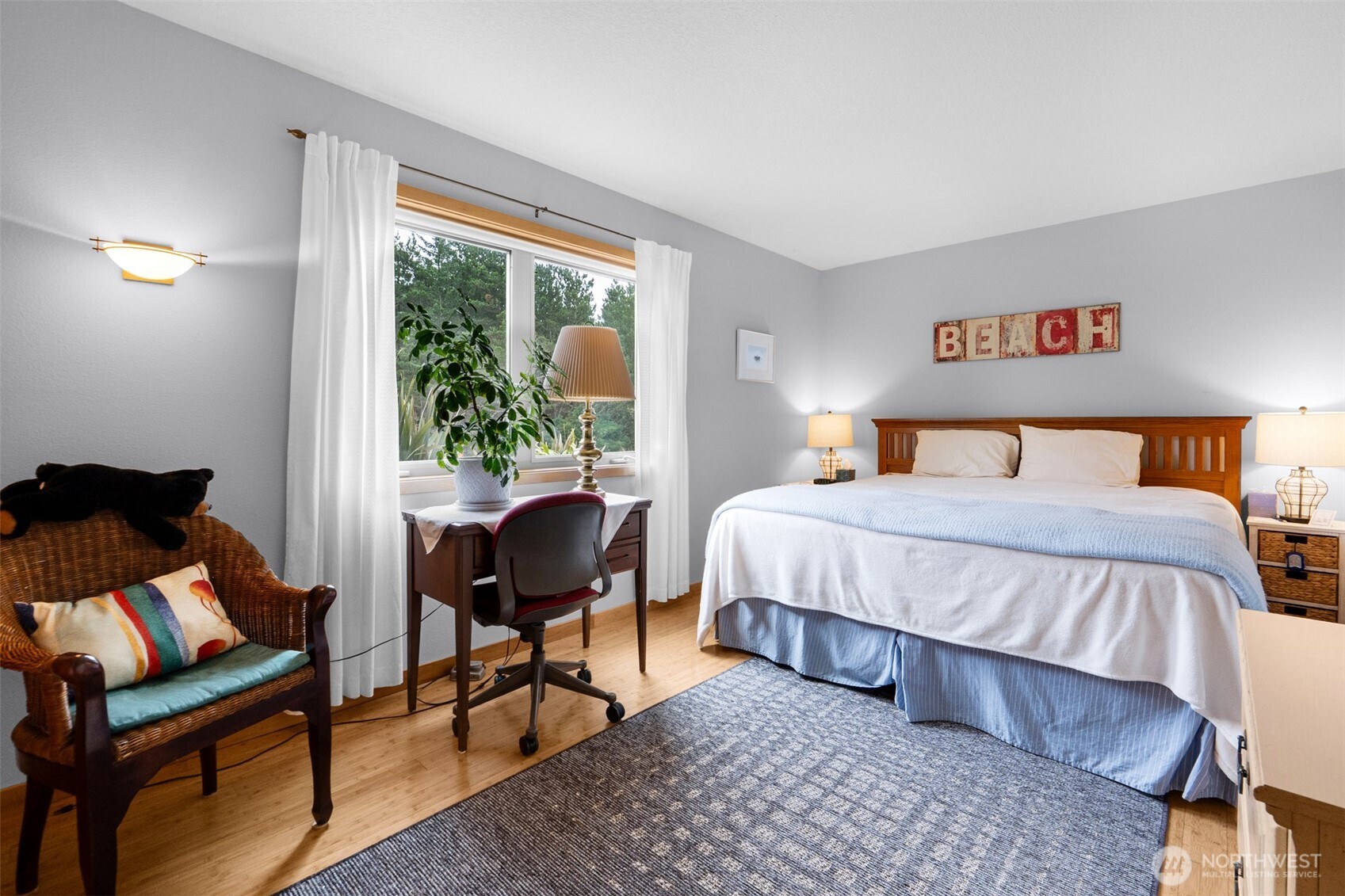 402 17th Street Southwest Long Beach, WA 98631 - Photo 17 of 32 a bedroom with a bed and wooden floor