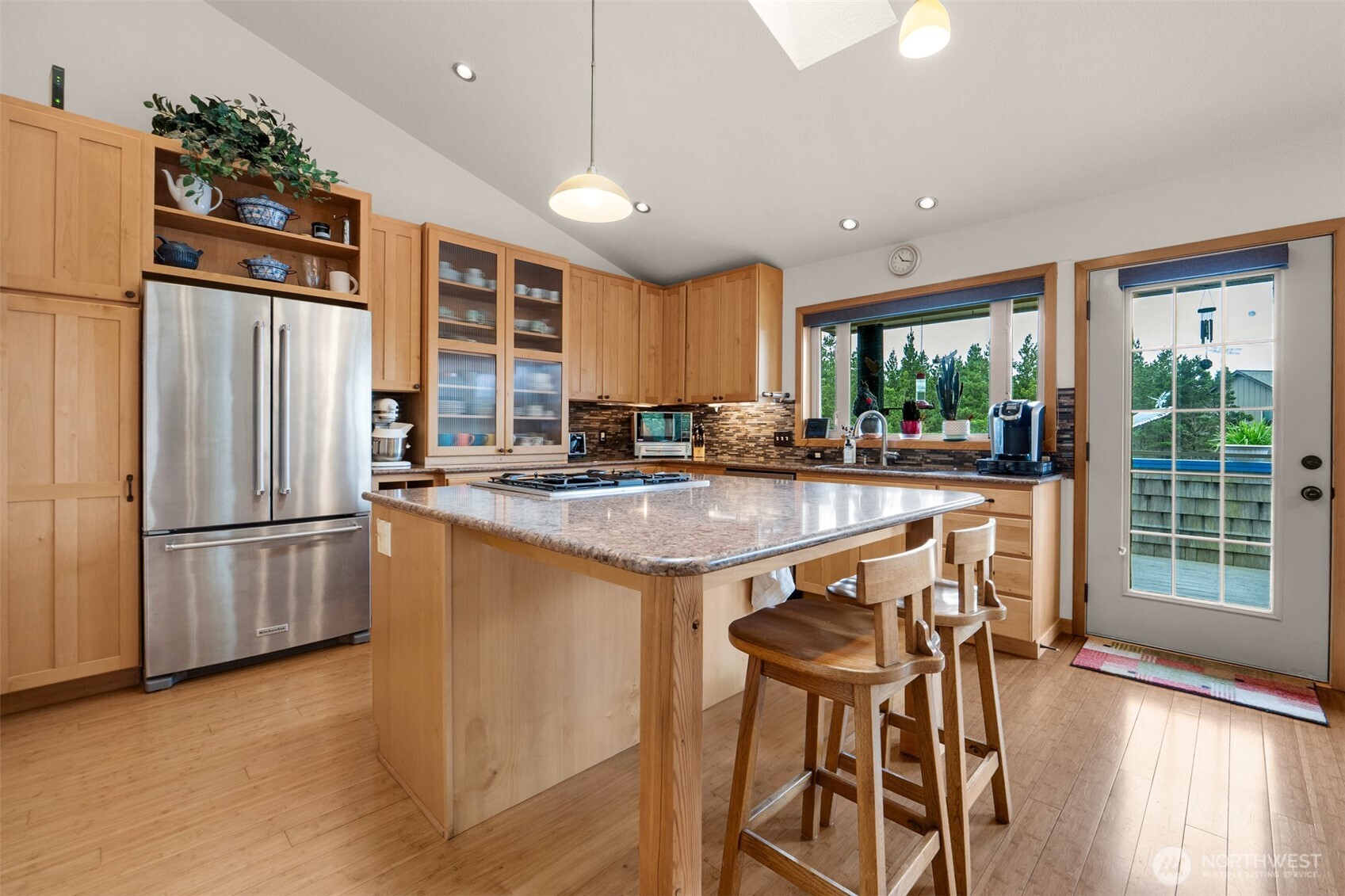 402 17th Street Southwest Long Beach, WA 98631 - Photo 4 of 32 a kitchen with stainless steel appliances granite countertop a refrigerator a sink a stove and a dining table with wooden floor