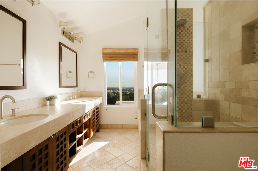 2669 Larmar Road Los Angeles, CA 90068 - Photo 8 of 16 a en suite bathroom with a double vanity sink a mirror and a shower
