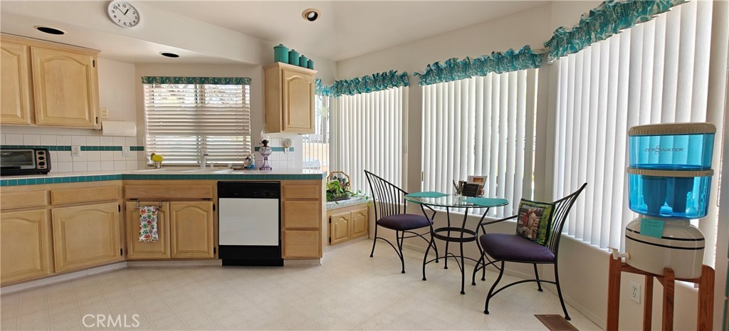 6144 Carodean Road Twentynine Palms, CA 92277 - Photo 45 of 71 a kitchen with stainless steel appliances a white table chairs and a large window