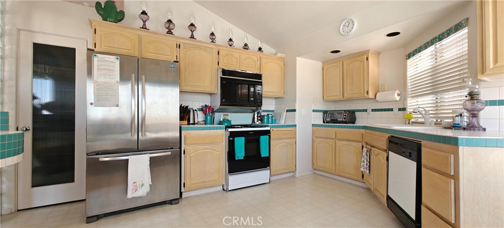 6144 Carodean Road Twentynine Palms, CA 92277 - Photo 46 of 71 a kitchen with stainless steel appliances kitchen island granite countertop a refrigerator a sink a stove and white cabinets