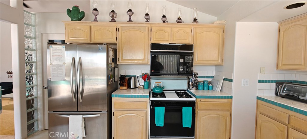 6144 Carodean Road Twentynine Palms, CA 92277 - Photo 48 of 71 a kitchen with stainless steel appliances kitchen island a refrigerator sink and stove