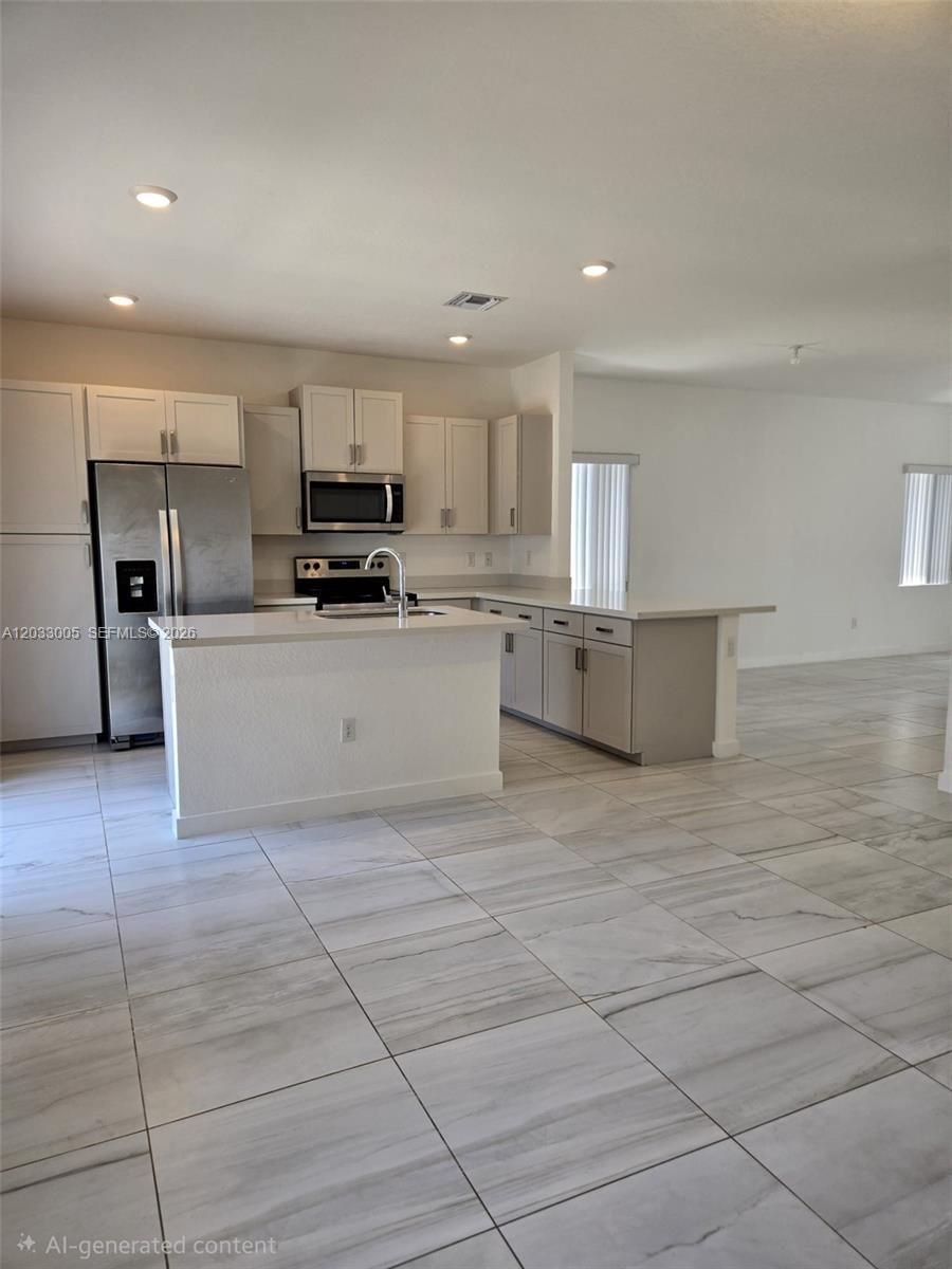 862 Southeast 17 Street, Unit 862 Homestead, FL 33034 - Photo 9 of 39 a kitchen with stainless steel appliances a refrigerator sink and microwave