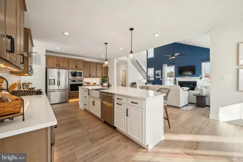 a large kitchen with stainless steel appliances kitchen island granite countertop a stove a sink a refrigerator and a fireplace